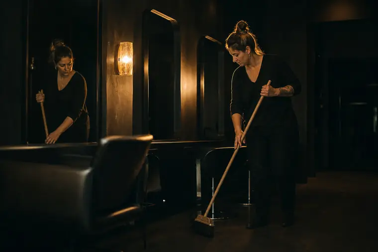 A salon owner sweeping her studio after closing time